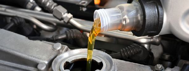 Oil being poured into an engine block that is silver